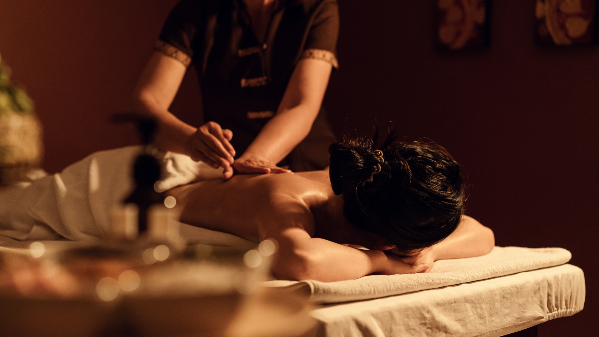 Frau erhält eine entspannende Rückenmassage von einem Masseur im Spa
