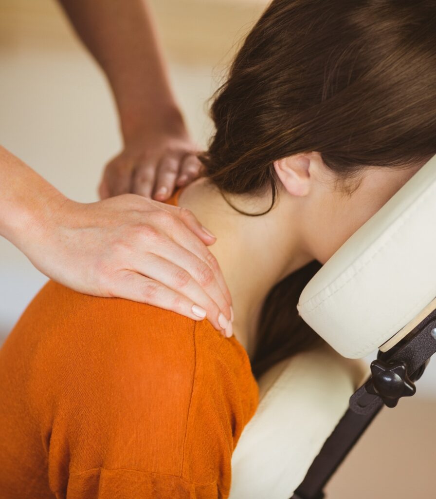 Junge Frau erhält eine Massage auf einem Massagestuhl