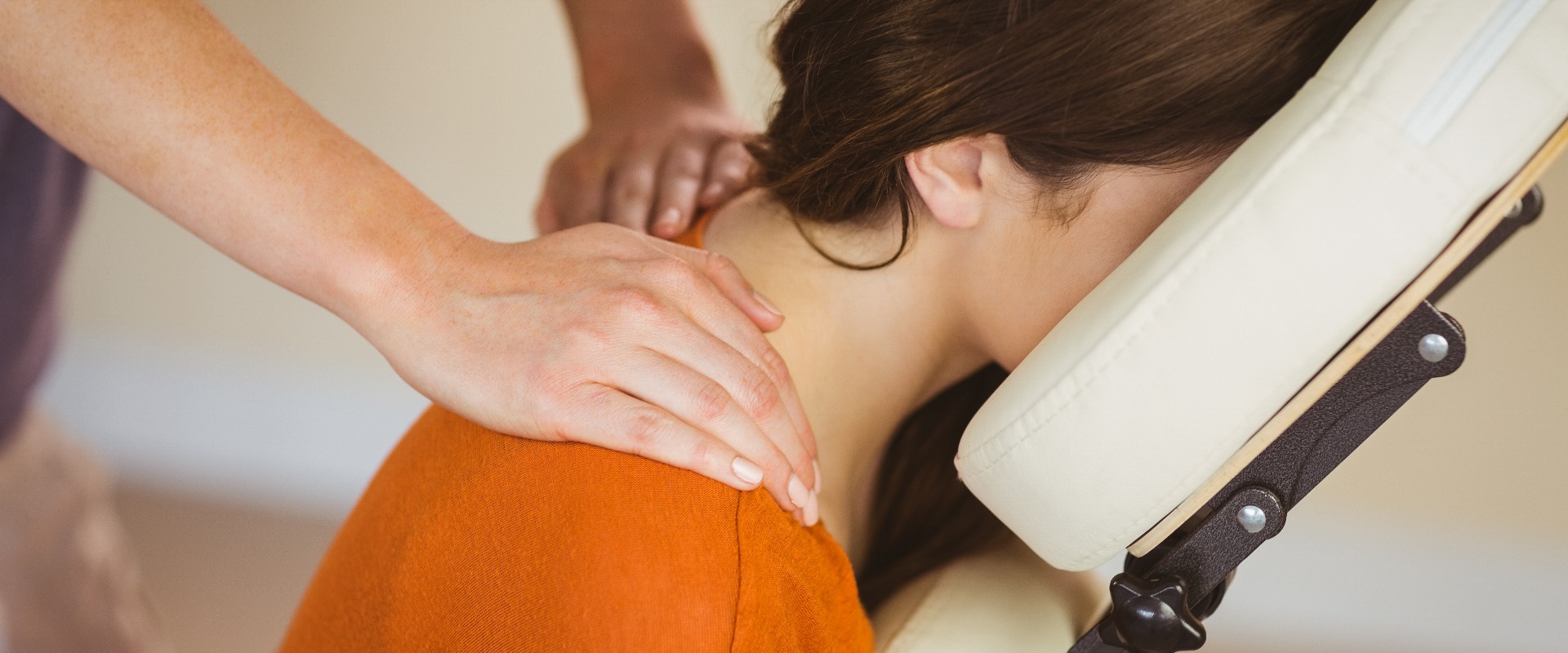 Junge Frau wird auf einem Stuhl massiert