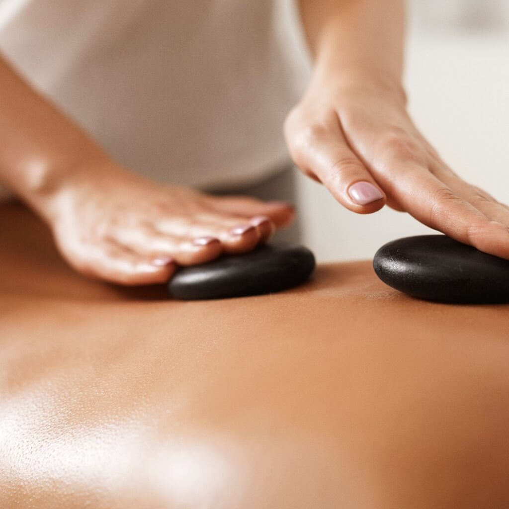 Masseur bei der Hot-Stone-Rückenmassage, Nahaufnahme