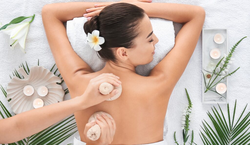 Beautiful young woman receiving massage in spa salon